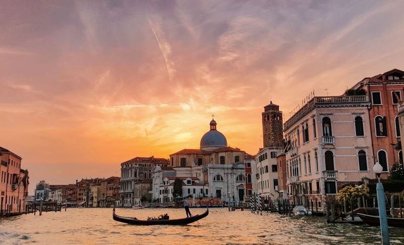 Gondole sur un canal de Venise au coucher du soleil.