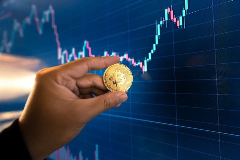 Pièce de Bitcoin dorée sur un graphique montrant une hausse des marchés financiers.