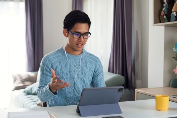 Étudiant utilisant une tablette pour un cours en ligne.
