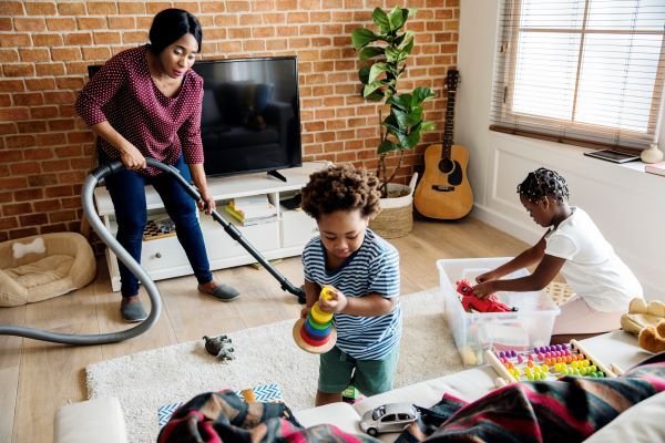 Mère et enfants nettoyant ensemble la maison lors du nettoyage de printemps.