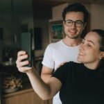 Couple souriant prenant un selfie à l'intérieur