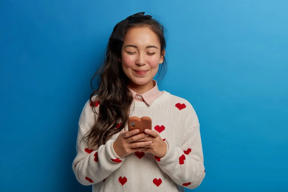 Femme asiatique souriante, symbolisant le succès et la satisfaction en amour