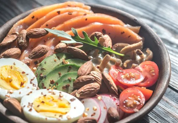 Bol composé de saumon, avocat et œuf, idéal pour une peau éclatante