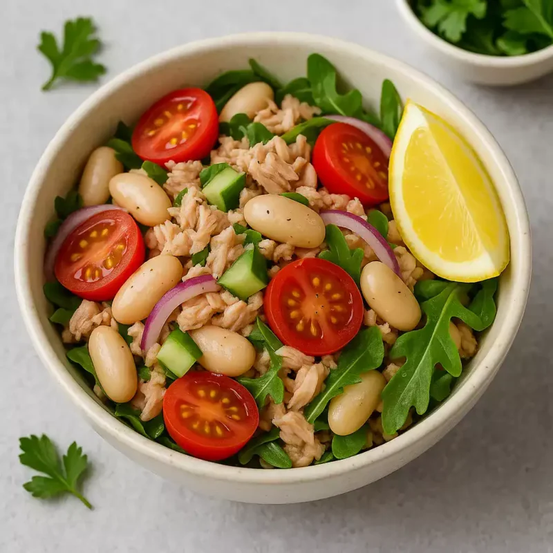 Salade de thon, haricots blancs, tomates cerises et oignons rouges dans un bol