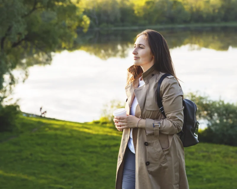 Femme sereine marchant dans un parc, symbole d'équilibre retrouvé