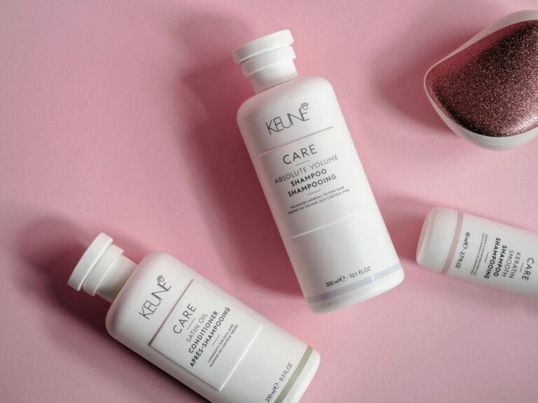 Flacons de shampoing et d'après-shampoing sur fond rose