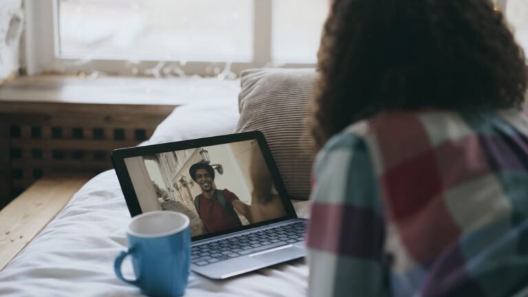 Femme en appel vidéo sur son ordinateur dans un salon chaleureux