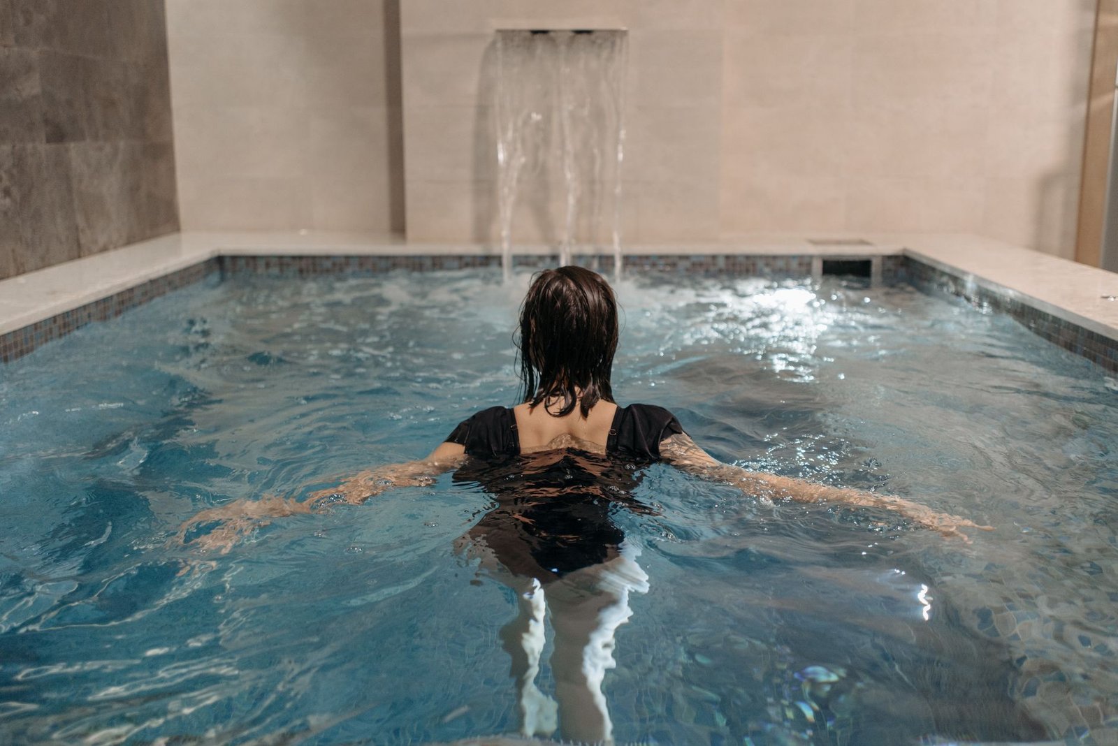 Femme nageant dans une piscine intérieure de spa
