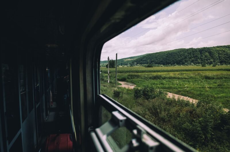 Campagne verte et collines vues depuis la fenêtre d'un train