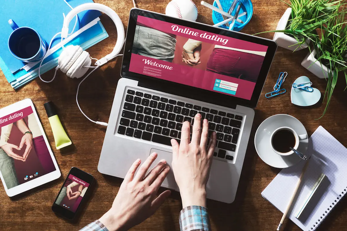 Personne utilisant un comparateur de sites de rencontre en ligne sur ordinateur, tablette et smartphone