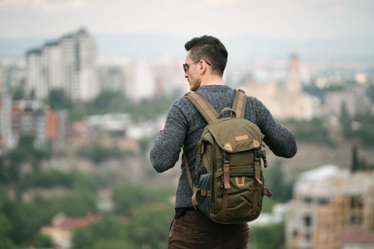 Voyageur sac au dos qui contemple une ville depuis les hauteurs