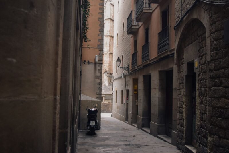 Une ruelle étroite et pavée de la vieille ville de Barcelone, entre de hautes façades de pierre
