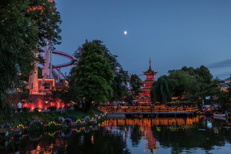 La pagode illuminée des jardins de Tivoli se reflétant dans le lac la nuit