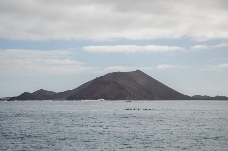 Kayaks dans l'eau turquoise au large de Corralejo, face à une île volcanique