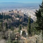 L'Alhambra de Grenade entourée de cyprès, avec la ville et la plaine en arrière-plan