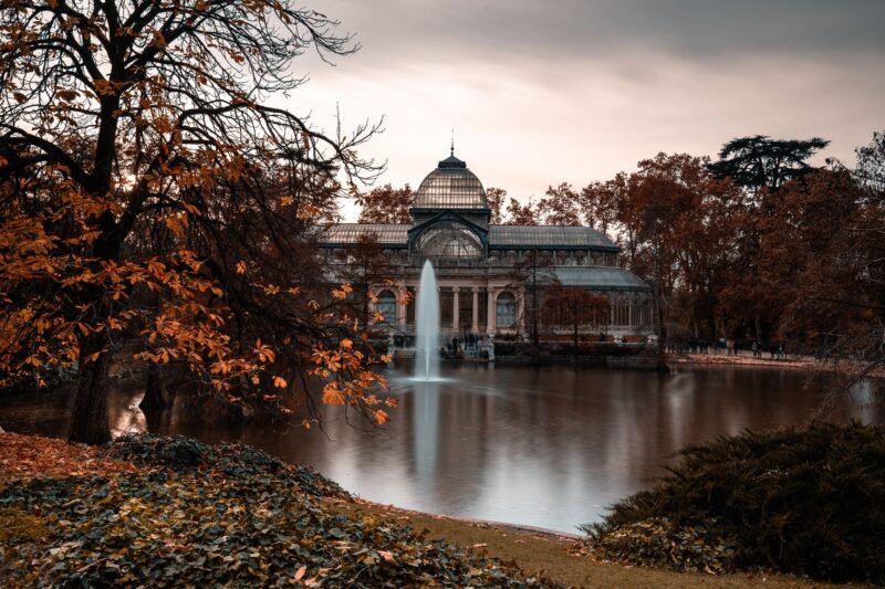 Le Palais de cristal du parc du Retiro à Madrid entouré d'arbres aux couleurs d'automne