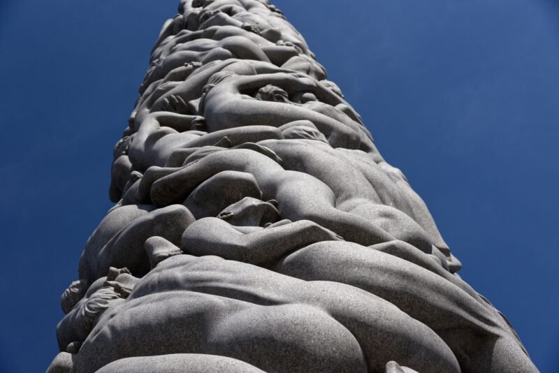 Le Monolithe du parc Vigeland, colonne de granit sculptée de corps entremêlés, sous un ciel bleu