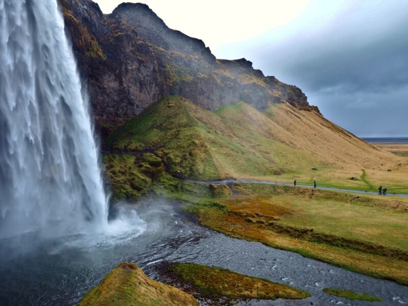 La cascade de Seljalandsfoss tombant d'une falaise couverte de mousse verte dans le sud de l'Islande