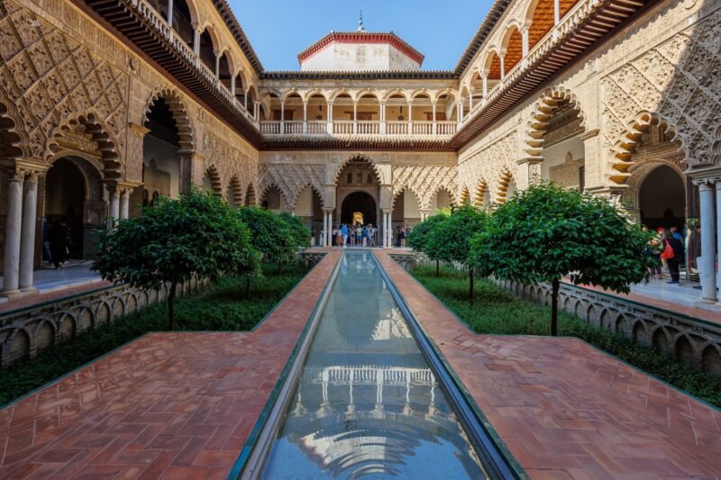 Patio du Real Alcázar de Séville avec ses arcs mauresques et sa végétation