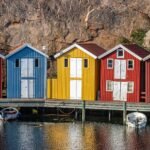 Des cabanes de pêcheurs colorées au pied d'une falaise, sur le port de Smögen, en Suède
